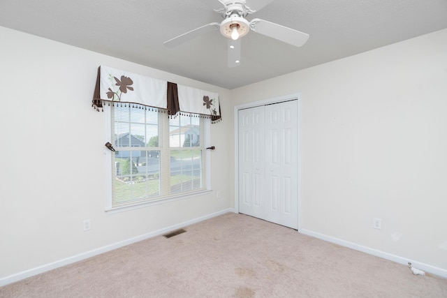 unfurnished room with carpet flooring, baseboards, and ceiling fan