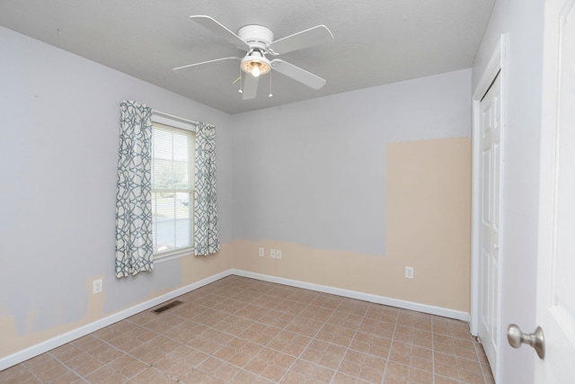 unfurnished room featuring a ceiling fan and baseboards