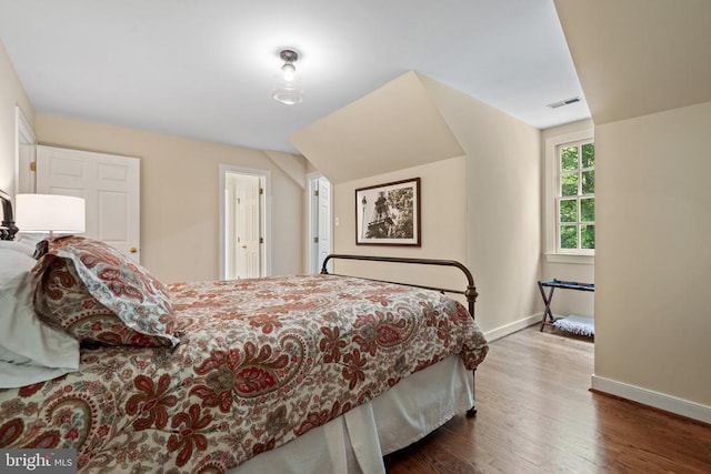  - bedroom featuring baseboards, wood finished floors, and vaulted ceiling