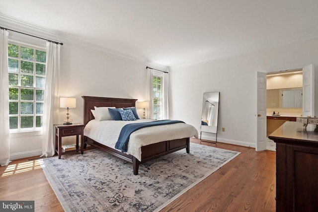  - bedroom with crown molding, multiple windows, baseboards, and wood finished floors