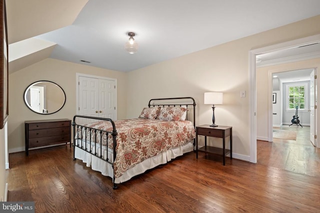  - bedroom featuring wood finished floors, baseboards, and a closet