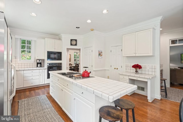  - kitchen with black appliances, tile countertops, white cabinets, dark wood-style flooring, and recessed lighting