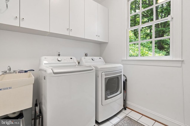  - laundry room featuring cabinet space, independent washer and dryer, light tile patterned floors, and baseboards