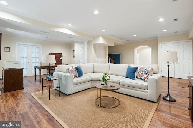  - living area featuring crown molding, wood finished floors, arched walkways, recessed lighting, and stairway
