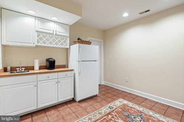  - kitchen with freestanding refrigerator, a sink, light countertops, white cabinetry, and recessed lighting
