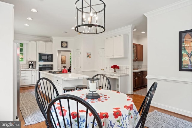  - dining area with light wood finished floors, recessed lighting, crown molding, a chandelier, and baseboards