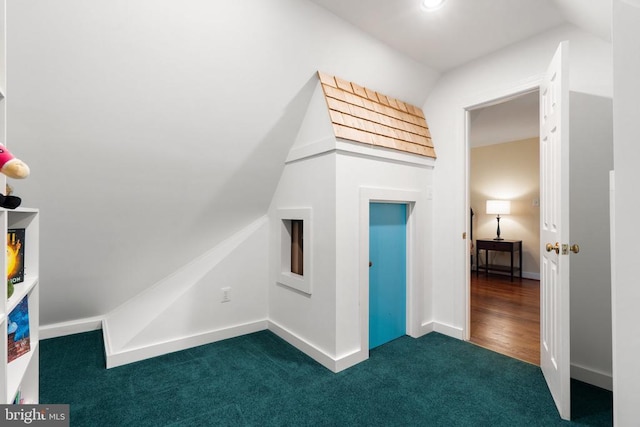  - additional living space with dark colored carpet and baseboards