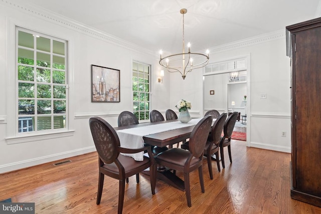  - dining room with a chandelier, crown molding, wood finished floors, and baseboards