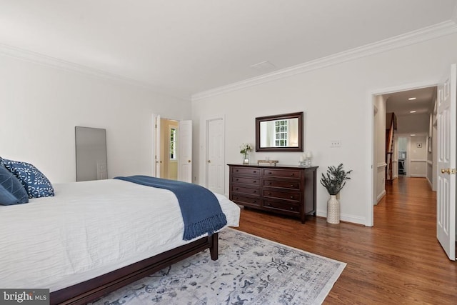  - bedroom with ornamental molding, wood finished floors, and baseboards