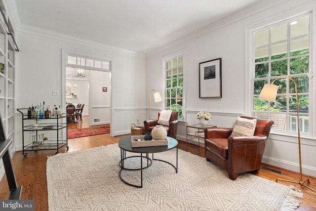  - living room featuring wood finished floors, crown molding, healthy amount of natural light, and a wainscoted wall