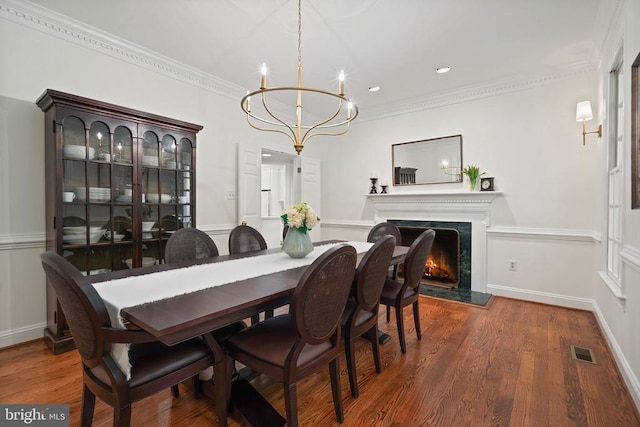  - dining space with a chandelier, ornamental molding, wood finished floors, recessed lighting, and a premium fireplace