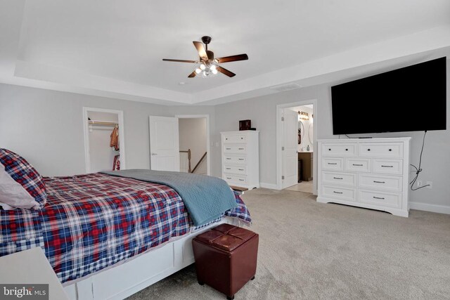1909 Artillery Ridge Rd, Fredericksburg, VA 22408 - bedroom featuring a tray ceiling, light colored carpet, baseboards, a walk in closet, and ensuite bath