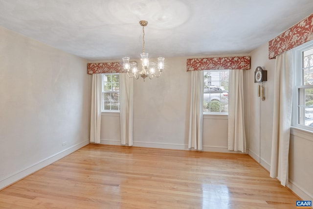 129 W Park Dr, Charlottesville, VA 22901 - unfurnished dining area featuring a healthy amount of sunlight, a chandelier, baseboards, and light wood finished floors
