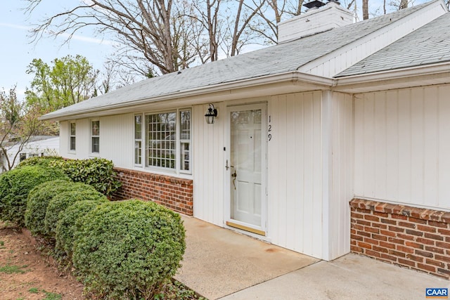 129 W Park Dr, Charlottesville, VA 22901 - property entrance with a chimney, brick siding, and a shingled roof