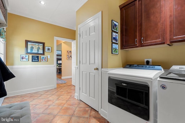  - washroom featuring washing machine and clothes dryer, cabinet space, ornamental molding, a wainscoted wall, and light tile patterned floors