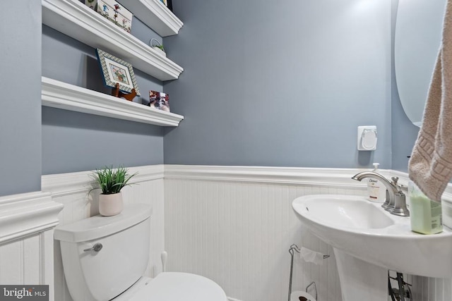  - half bathroom featuring wainscoting and toilet