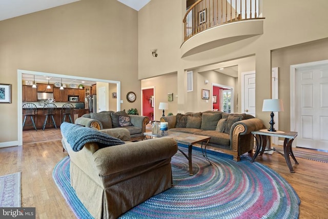  - living room featuring light wood-style floors and high vaulted ceiling