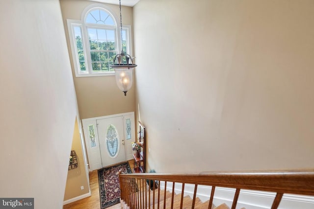  - foyer entrance featuring wood finished floors, a high ceiling, and stairway