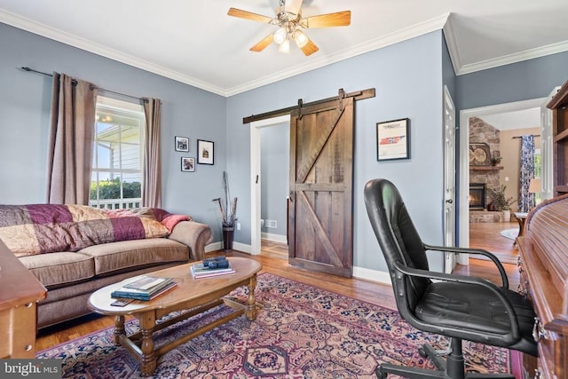  - office area with a barn door, wood finished floors, plenty of natural light, a ceiling fan, and crown molding