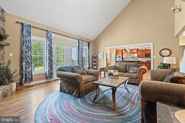  - living room with high vaulted ceiling and light wood-style floors