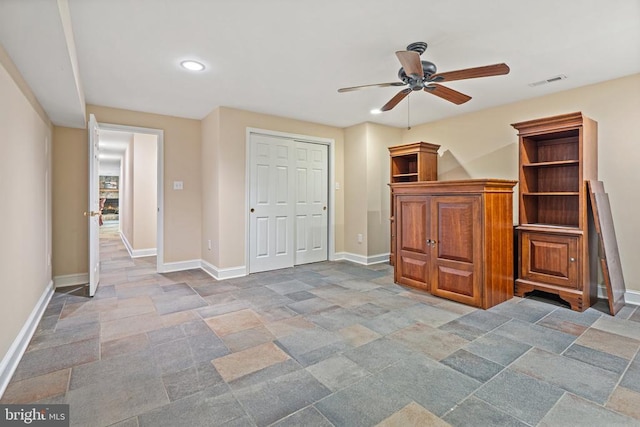  - unfurnished bedroom featuring stone tile flooring, recessed lighting, a closet, and a ceiling fan