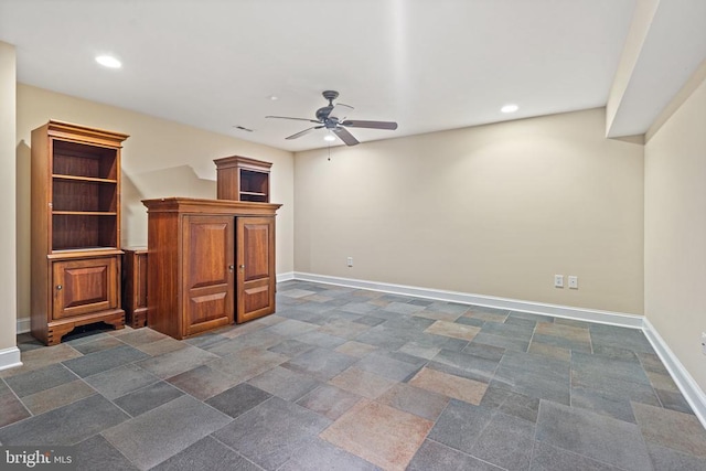  - unfurnished living room featuring a ceiling fan, recessed lighting, and dark stone finish floors