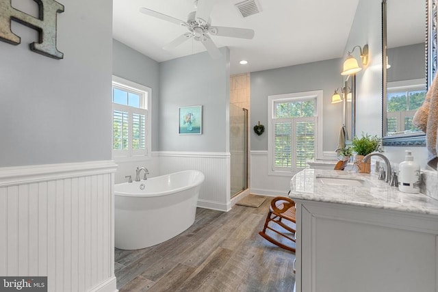  - bathroom with a wainscoted wall, wood finished floors, a freestanding tub, a shower stall, and vanity