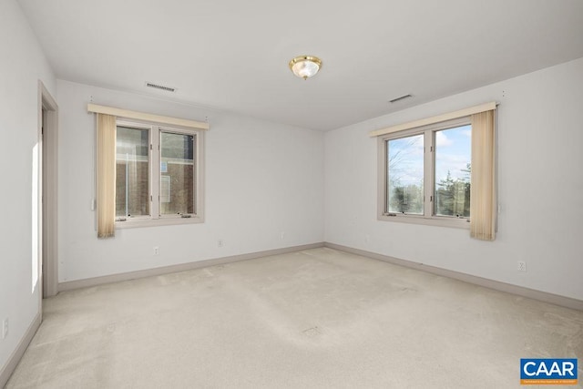 unfurnished room featuring baseboards, visible vents, and carpet