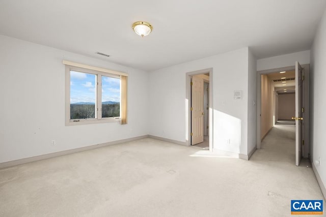 unfurnished bedroom featuring baseboards, visible vents, and light colored carpet