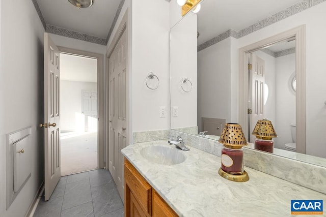 bathroom with toilet, tile patterned flooring, and vanity