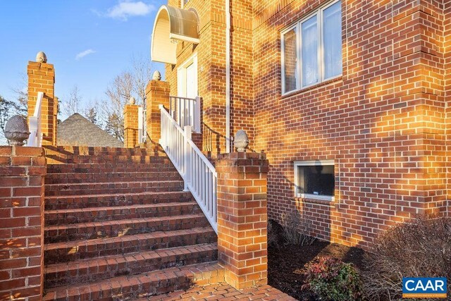 view of property exterior featuring stairs and brick siding