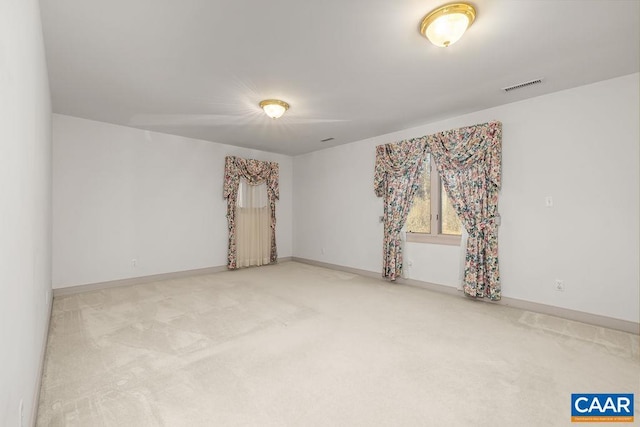 empty room featuring carpet flooring, baseboards, and visible vents