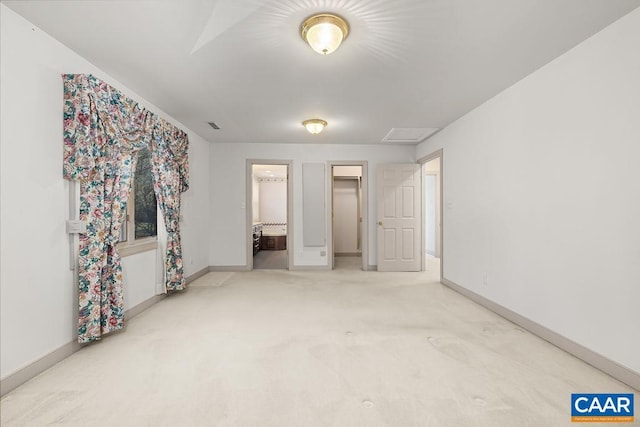 unfurnished bedroom with baseboards, ensuite bathroom, carpet floors, and a walk in closet