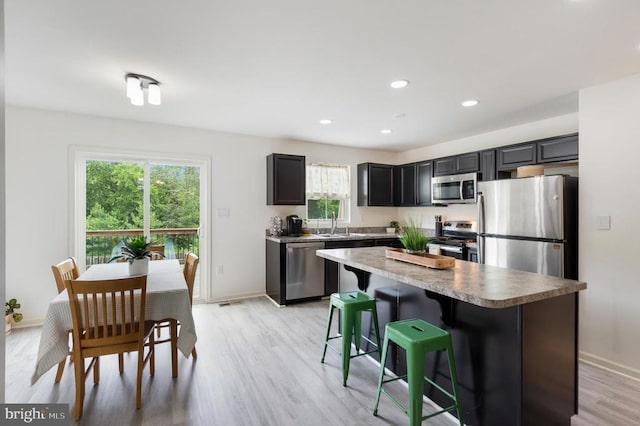 5014 Godwins Landing Dr, Remington, VA 22734 - kitchen featuring appliances with stainless steel finishes, light wood finished floors, a kitchen island, a breakfast bar, and recessed lighting