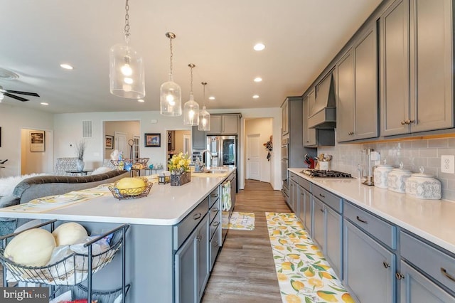 11726 Robin Woods Cir, Spotsylvania, VA 22551 - kitchen with gray cabinets, custom range hood, open floor plan, a sink, and recessed lighting
