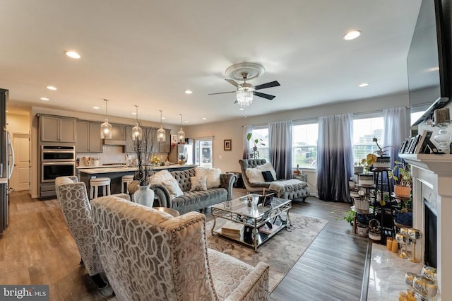 11726 Robin Woods Cir, Spotsylvania, VA 22551 - living room with a fireplace with flush hearth, a ceiling fan, recessed lighting, and light wood-style floors