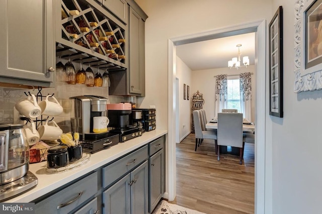 11726 Robin Woods Cir, Spotsylvania, VA 22551 - bar featuring backsplash, a chandelier, and light wood-style flooring