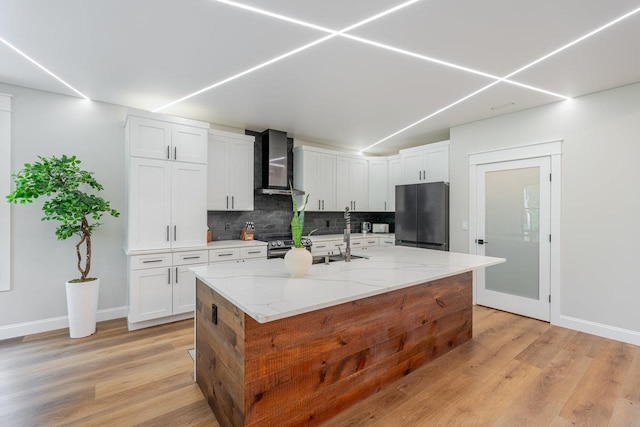 10 Samuel Bears Rd, Weyers Cave, VA 24486 - kitchen with wall chimney range hood, stainless steel appliances, tasteful backsplash, light wood-style flooring, and white cabinets