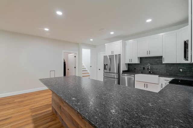 10 Samuel Bears Rd, Weyers Cave, VA 24486 - kitchen with appliances with stainless steel finishes, a sink, light wood finished floors, white cabinets, and tasteful backsplash