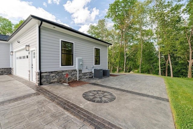 10 Samuel Bears Rd, Weyers Cave, VA 24486 - view of side of home featuring driveway, stone siding, a garage, and central AC unit
