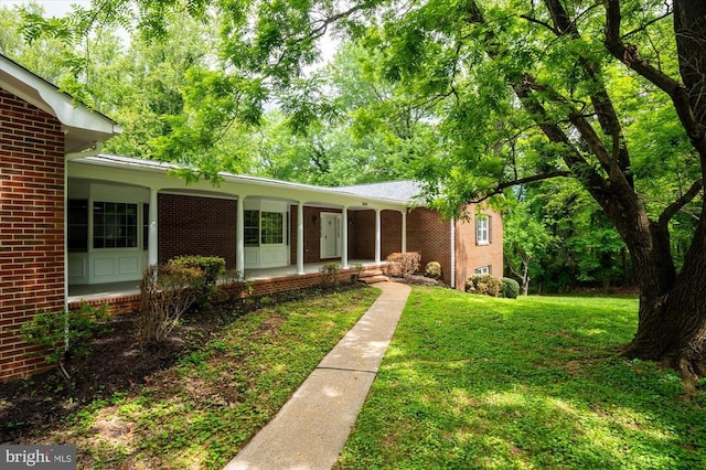 single story home featuring brick siding and a front lawn