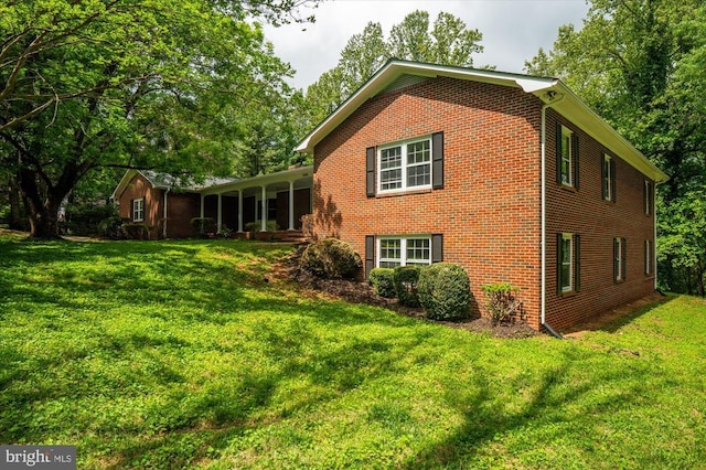view of side of property featuring a yard and brick siding