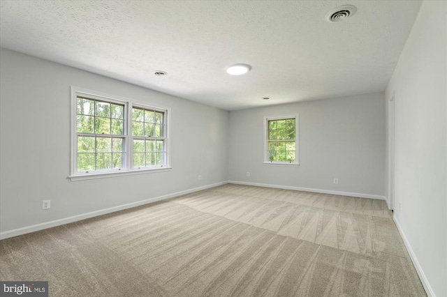 empty room featuring baseboards, a textured ceiling, and carpet floors