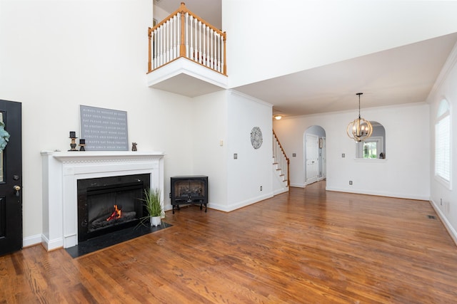 47 Villa View Dr, Staunton, VA 24401 - unfurnished living room with stairway, arched walkways, wood finished floors, a chandelier, and ornamental molding