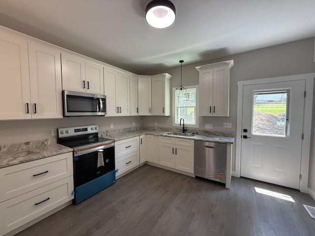 1522 2nd St, Waynesboro, VA 22980 - kitchen featuring appliances with stainless steel finishes, dark wood-type flooring, white cabinetry, decorative light fixtures, and light stone counters