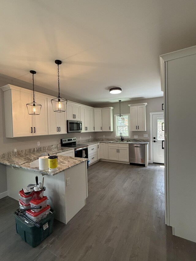1522 2nd St, Waynesboro, VA 22980 - kitchen featuring appliances with stainless steel finishes, a peninsula, dark wood finished floors, white cabinets, and pendant lighting