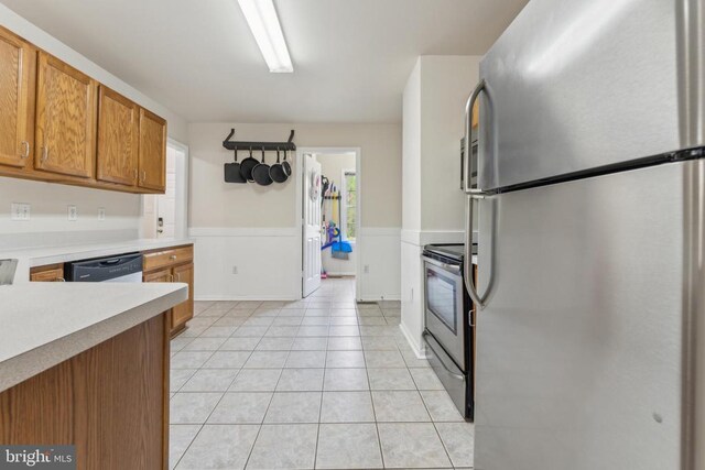 10108 Chesney Dr, Spotsylvania, VA 22553 - kitchen with stainless steel appliances, light countertops, brown cabinetry, and light tile patterned floors