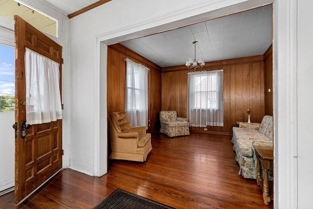 105 Austin Ave, Staunton, VA 24401 - living area with a chandelier, wood finished floors, baseboards, wood walls, and ornamental molding