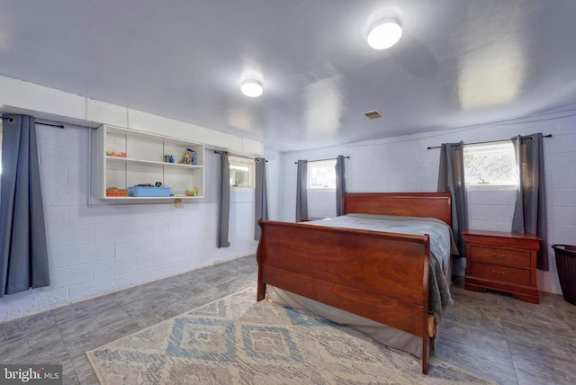  - bedroom featuring concrete block wall