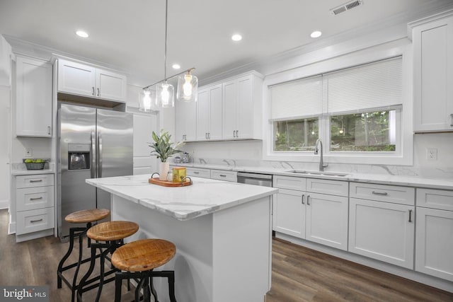 10302 Laurel Ridge Way, Fredericksburg, VA 22408 - kitchen featuring appliances with stainless steel finishes, a sink, a kitchen island, a breakfast bar, and white cabinetry
